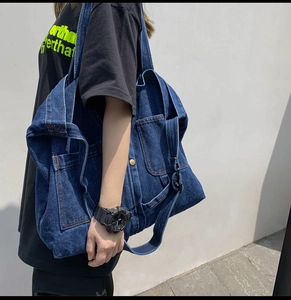Detail of vintage navy blue denim tote bag showing multi-pocket design and wide strap