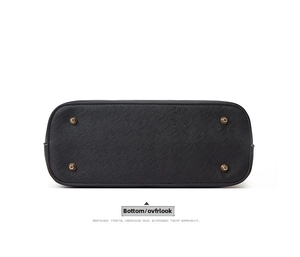 Close-up of black Saffiano leather tote bag bottom with four bronze protective metal feet
