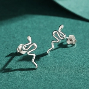Abstract snake-shaped S925 sterling silver stud earrings on green felt background