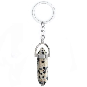 Detail of natural beige spotted stone hexagonal pendant with silver metal keychain