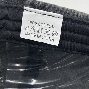 Close-up of 100% cotton wash label and care instructions inside the grey baseball cap