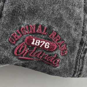 Detailed macro view of vintage embroidery with 'Orlando 1876' on washed cotton fabric