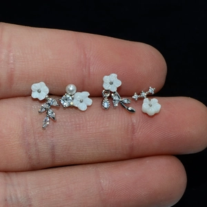 Floral stainless steel stud earrings with zircon and pearl accents on fingertips
