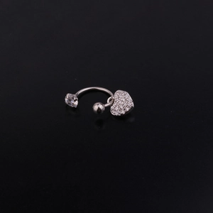 Close-up of silver curved barbell with crystal heart pendant and zircon stone