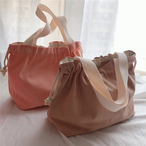 Detail of pink and brown thick canvas tote bags with drawstring closure and wide straps