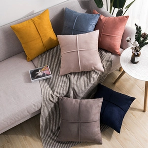 Close-up of assorted plush faux rabbit fur pillow covers in various colors on a sofa