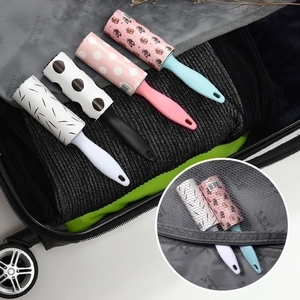 Portable mini lint roller set with four colorful refill rolls in an open travel suitcase