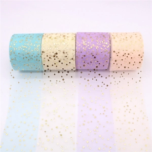 Detail of four tulle rolls with gold stars in blue, yellow, purple and pink colors