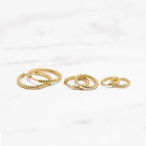 Three sets of S925 sterling silver gold plated twist hoop earrings on marble