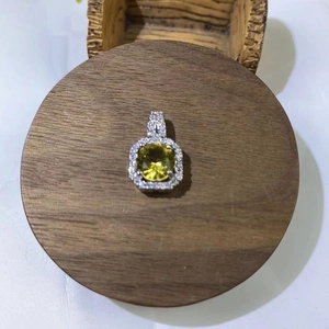 Detailed view of square yellow crystal pendant with pavé cubic zirconia on wooden stand