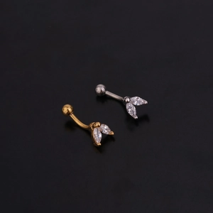 Macro shot of gold and silver curved barbell piercings with marquise-cut zircon stones