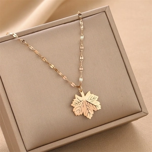 Rose gold maple leaf pendant necklace on champagne jewelry box with a flat link chain