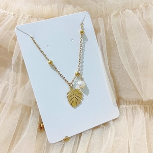 French style gold compass pearl necklace with monstera leaf pendant on lace