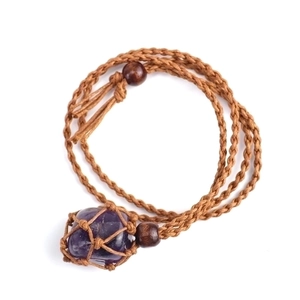 Detailed view of hand-woven brown cord net holding a raw deep purple amethyst crystal stone