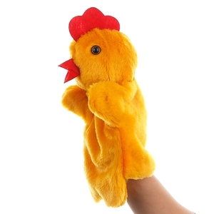 Détail macro d'une main portant une marionnette à main poulet jaune en peluche douce