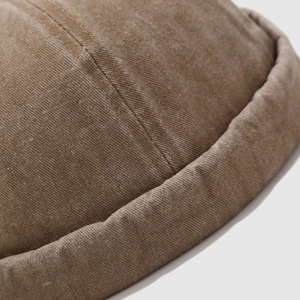 Close-up of brown cotton twill brimless docker hat showing stitching and fabric texture