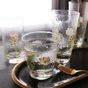 Hammered daisy pattern glass cups in tall and short sizes on an elegant tea tray