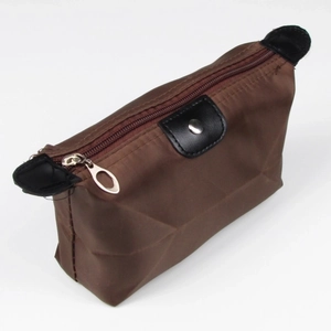 Detailed view of the brown nylon makeup organizer pouch with black trim and snap closure