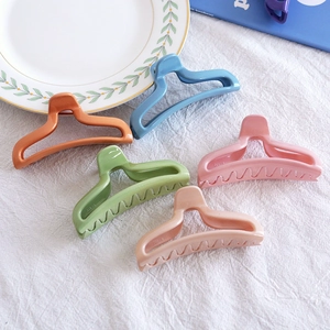Matte candy-colored large hair claws set in orange, blue, and green on white fabric