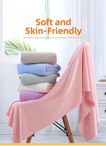 Close-up of soft coral fleece bath towels with decorative wavy scalloped edge details