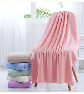 Detailed pile texture of soft coral fleece bath towels in various pastel colors