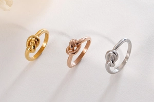 Detailed close-up of knot rings in gold, rose gold, and silver polished finishes
