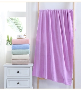 Hanging purple coral fleece bath towel with stacked multi-colored microfiber towels