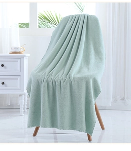 Detail of soft mint green coral fleece bath towel with elegant scalloped wave edge