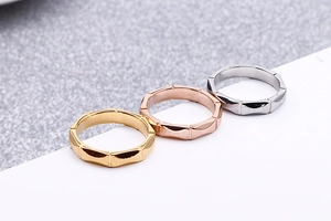 Close-up of geometric titanium steel rings with brushed finish in gold, rose gold and silver