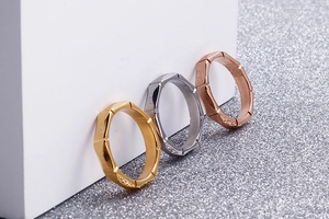 Detailed view of three minimalist geometric rings in gold, silver and rose gold finishes