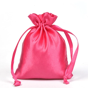 Detailed view of pink satin drawstring storage bag with silky texture and ribbon closure