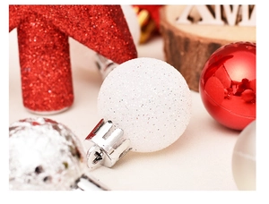 Close-up of white glitter Christmas ball with red star ornaments on festive background