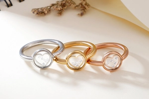 Detailed view of silver, gold, and rose gold heart rings with floating crystals