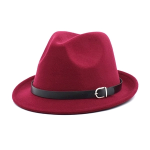 Detail of burgundy wool fedora hat featuring a black leather band and silver metal buckle