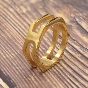 Close-up of golden geometric hexagonal double-row ring with polished metal finish