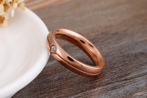 Macro shot of rose gold titanium ring featuring a grooved band and small inlaid diamond