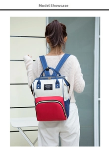Rear view of a stylish tri-color oxford fabric diaper backpack worn by a model