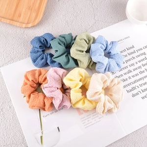 Close-up of pleated seersucker scrunchies in 8 colors displayed on a magazine