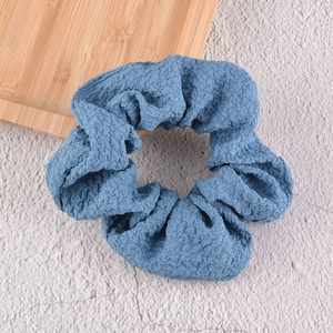 Détail du chouchou en seersucker bleu avec texture plissée sur fond texturé moderne