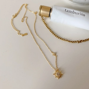 Close-up of S925 sterling silver hallmark on gold starburst pendant necklace chain