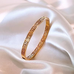Vintage style gold titanium steel bangle with hollow geometric Great Wall pattern