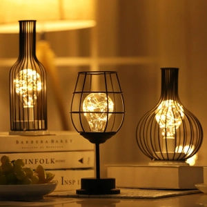 Cozy home decor featuring three black wire frame LED lamps with warm fairy lights bulbs