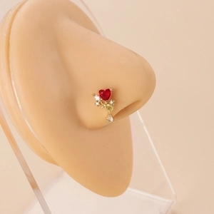 L-shaped gold nose stud featuring a red heart stone and crystal dangle on a model