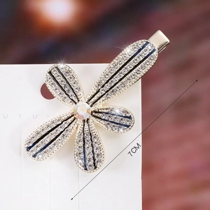 Close-up of 7cm elegant floral hair clip with crystals and blue accents on a card