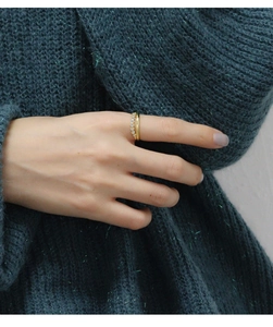 Close-up of double-layered 18K gold ring with fine row of diamonds on female finger