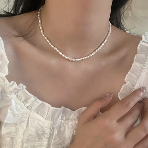 Close-up of elegant rice-shaped freshwater pearl necklace worn on model neck