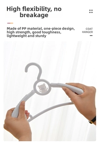 Detail of high-flexibility gray plastic children's coat hanger being bent to show durability
