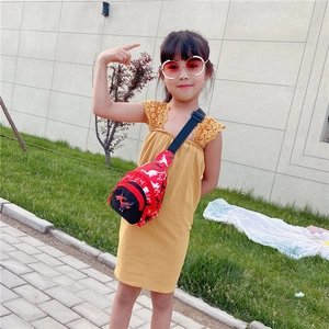 Close-up of red kids chest bag with white dinosaur patterns and adjustable black strap