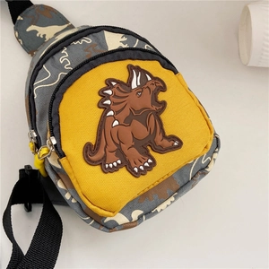 Close-up of children's camo dinosaur chest bag featuring a yellow front pocket and triceratops patch