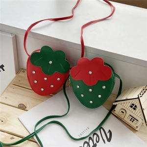 Detailed strawberry crossbody bag with crystal embellishments and green leaf flap